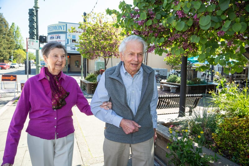 Senior couple walking arm in arm through Oakland 