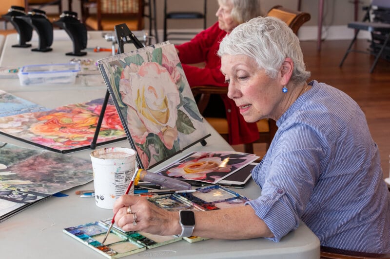 Senior woman painting a flower