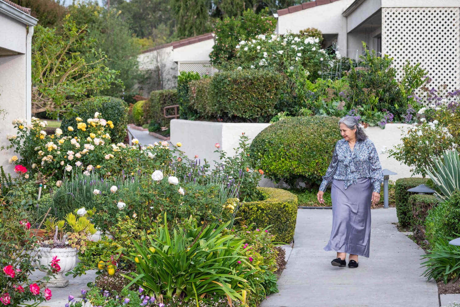 Senior woman walking through outdoor garden