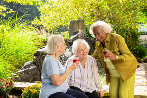 Three senior women talking on patio