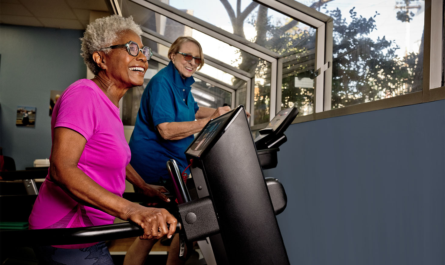 Two senior women using exercise machines in the Piedmont Gardens fitness center