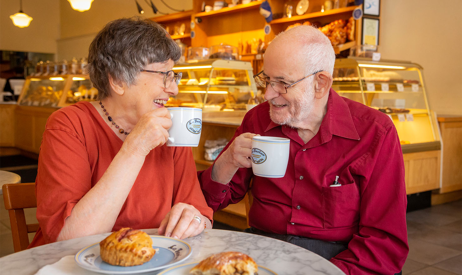 Senior couple enjoying coffee and pastries at the cafe at Piedmont Gardens