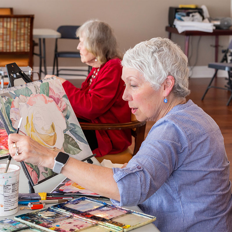 Two senior women painting in the art studio at Piedmont Gardens