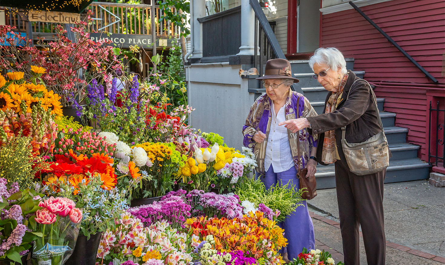 Two senior women looking at bouquets of a variety of colorful flowers