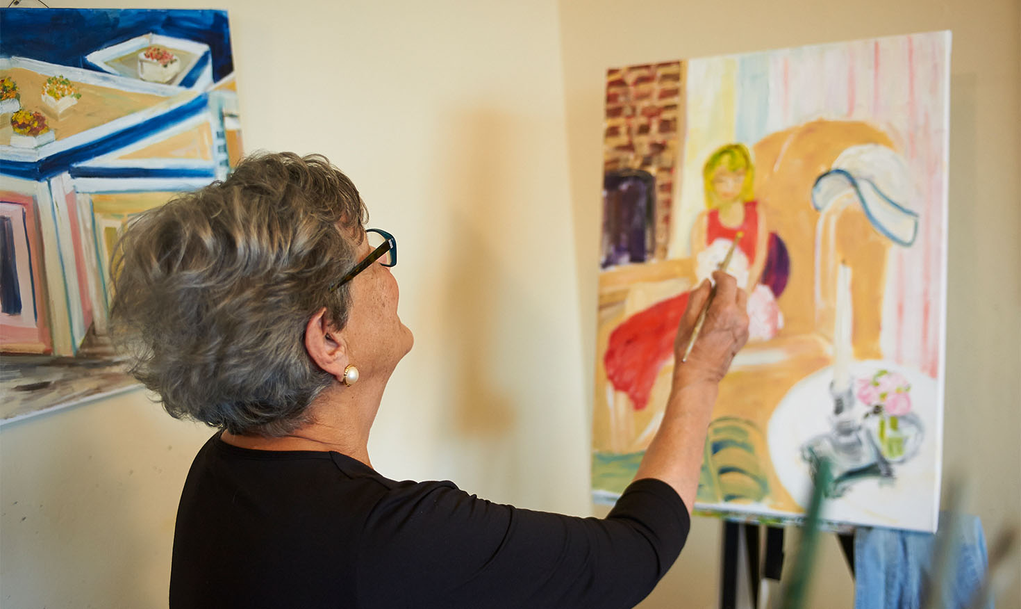 Senior woman painting on a canvas