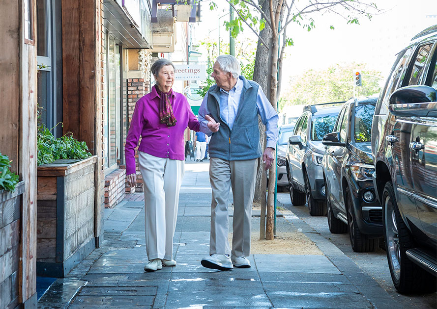 Senior man and woman walking through town