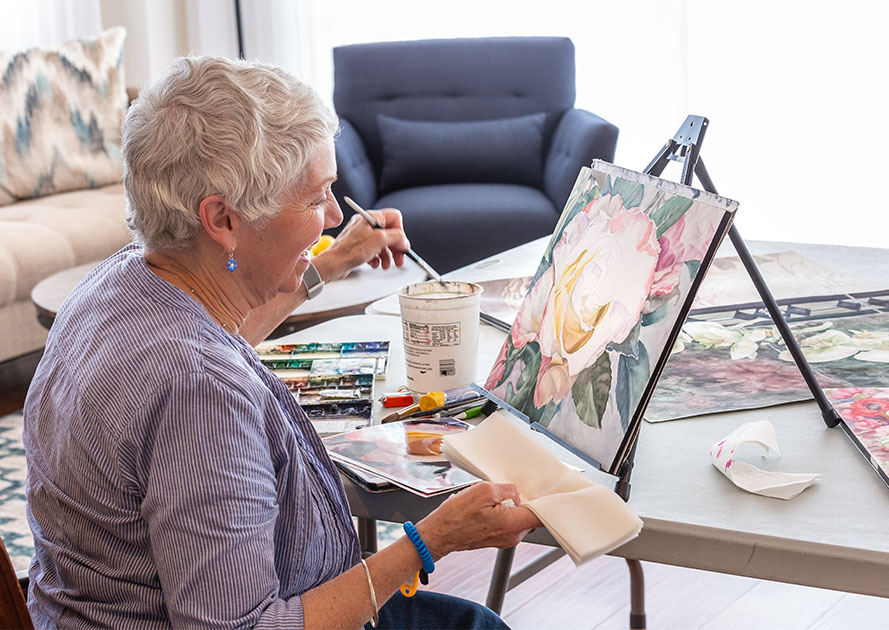 Senior woman painting a flower