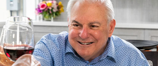 Senior man clinking wine glass at a restaurant