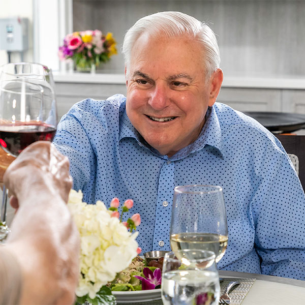 Senior man clinking wine glass at a restaurant