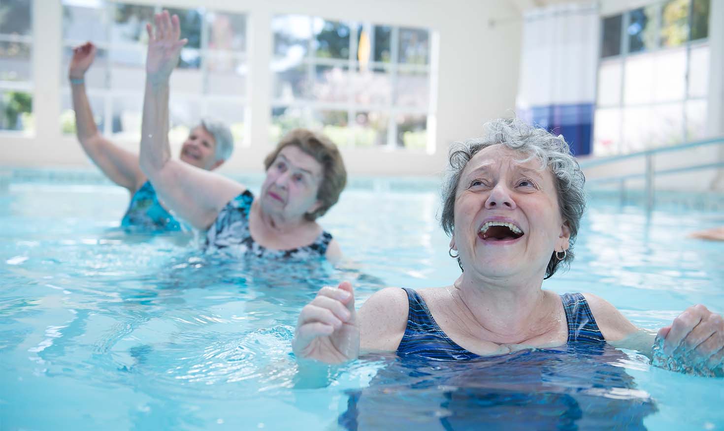 Senior women doing water aerobics in the indoor pool at Redwood Terrace