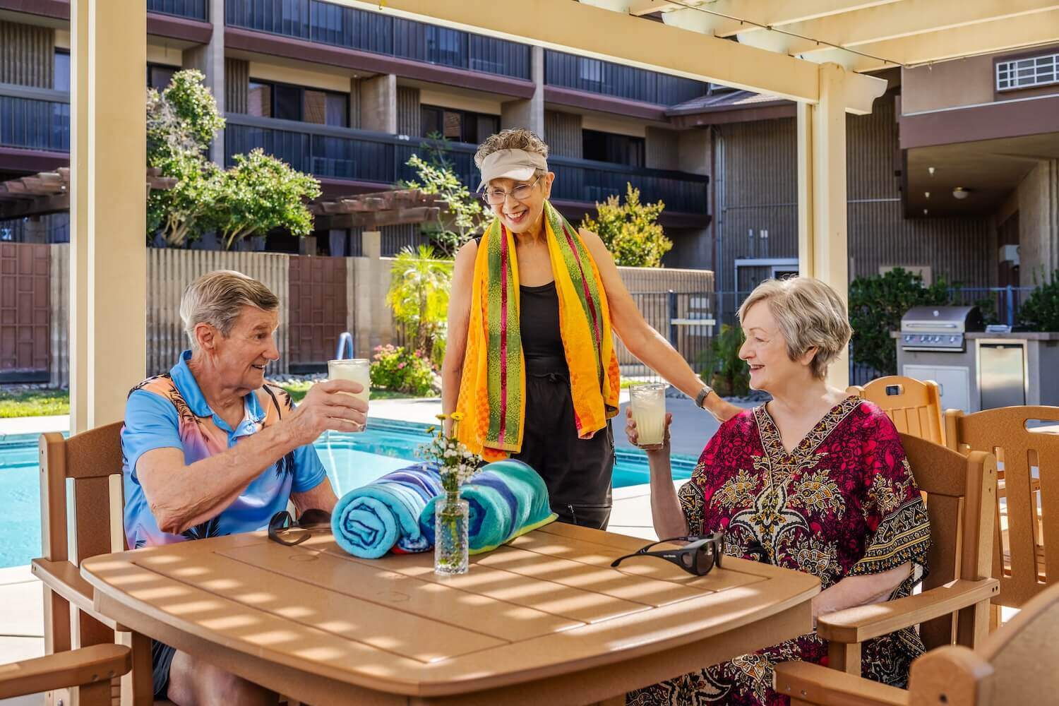 people sitting at a table by the pool