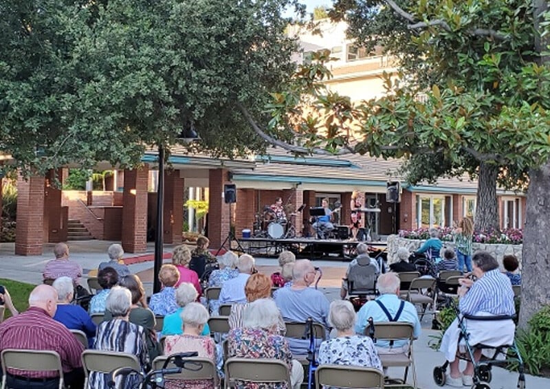 Group of seniors gathering outside to listen to live music