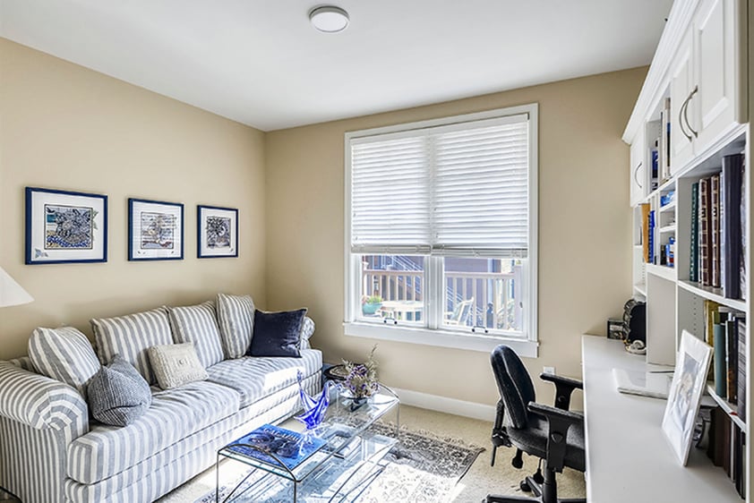 Light and bright living room space with a couch and built-in desk/storage of an apartment at The Terraces at Los Altos