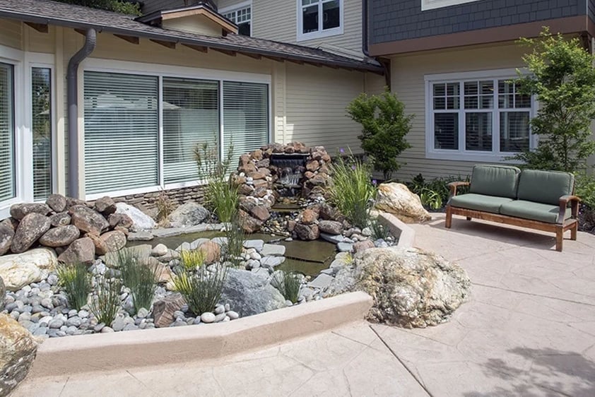 Stone garden and plants with a bench at The Terraces at Los Altos