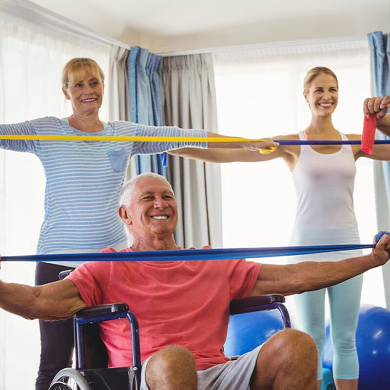 Senior man and senior woman working with a personal trainer and using resistance bands