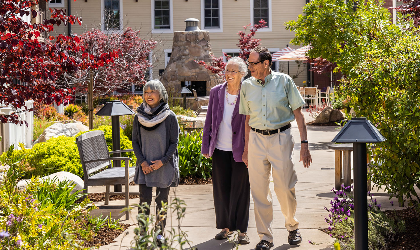 Two senior women and a senior man walking through the grounds of The Terraces at Los Altos