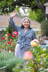 Senior woman in garden waving