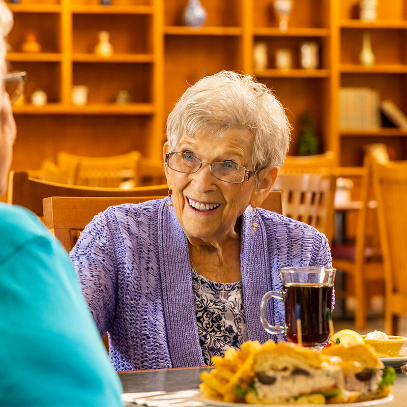 Senior woman eating lunch in The Terraces at Summitview dining room