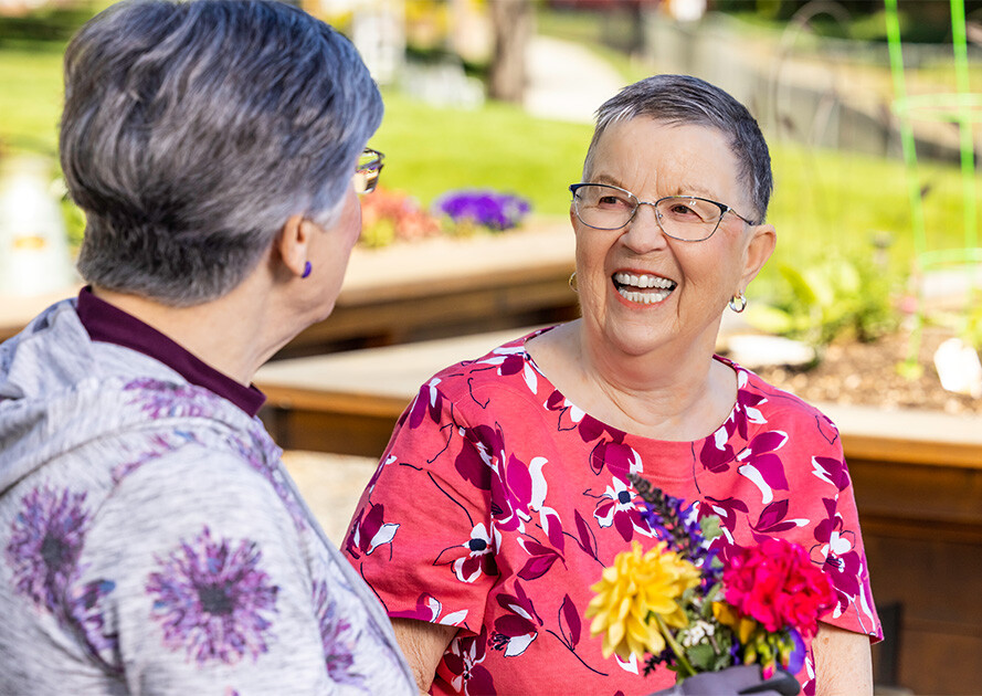 Two senior women talking in the garden at The Terraces at Summitview