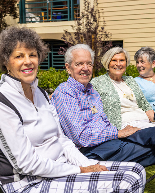 Four seniors sitting side by side outside The Terraces of Los Gatos