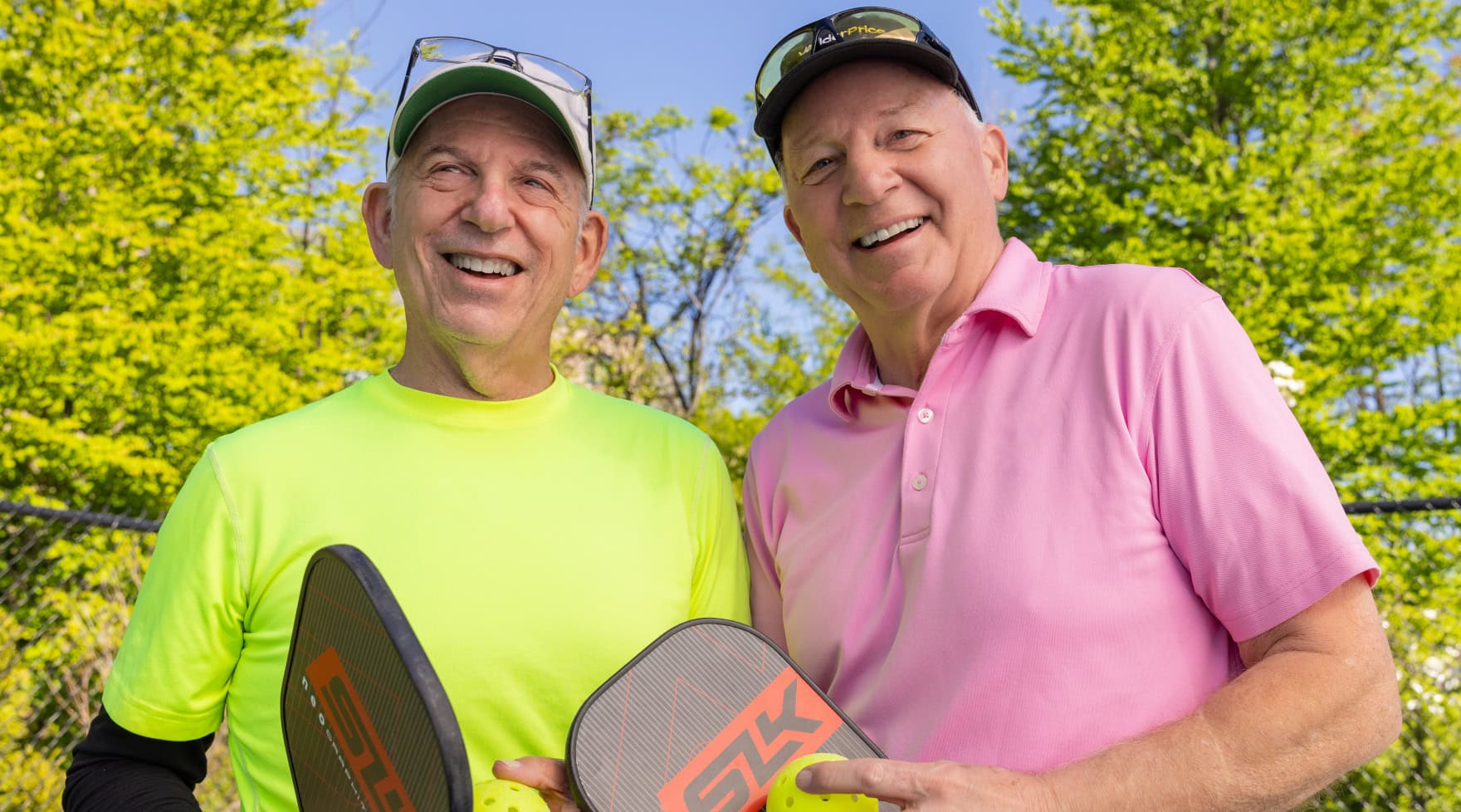 Two men holding pickleball paddles 