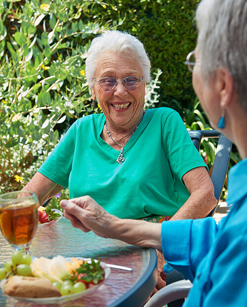 Two senior women eating outdoors