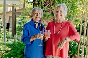 Two senior women enjoying a drink on a patio at Valle Verde