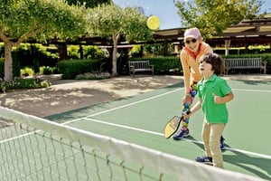 Senior woman playing pickleball with her grandson