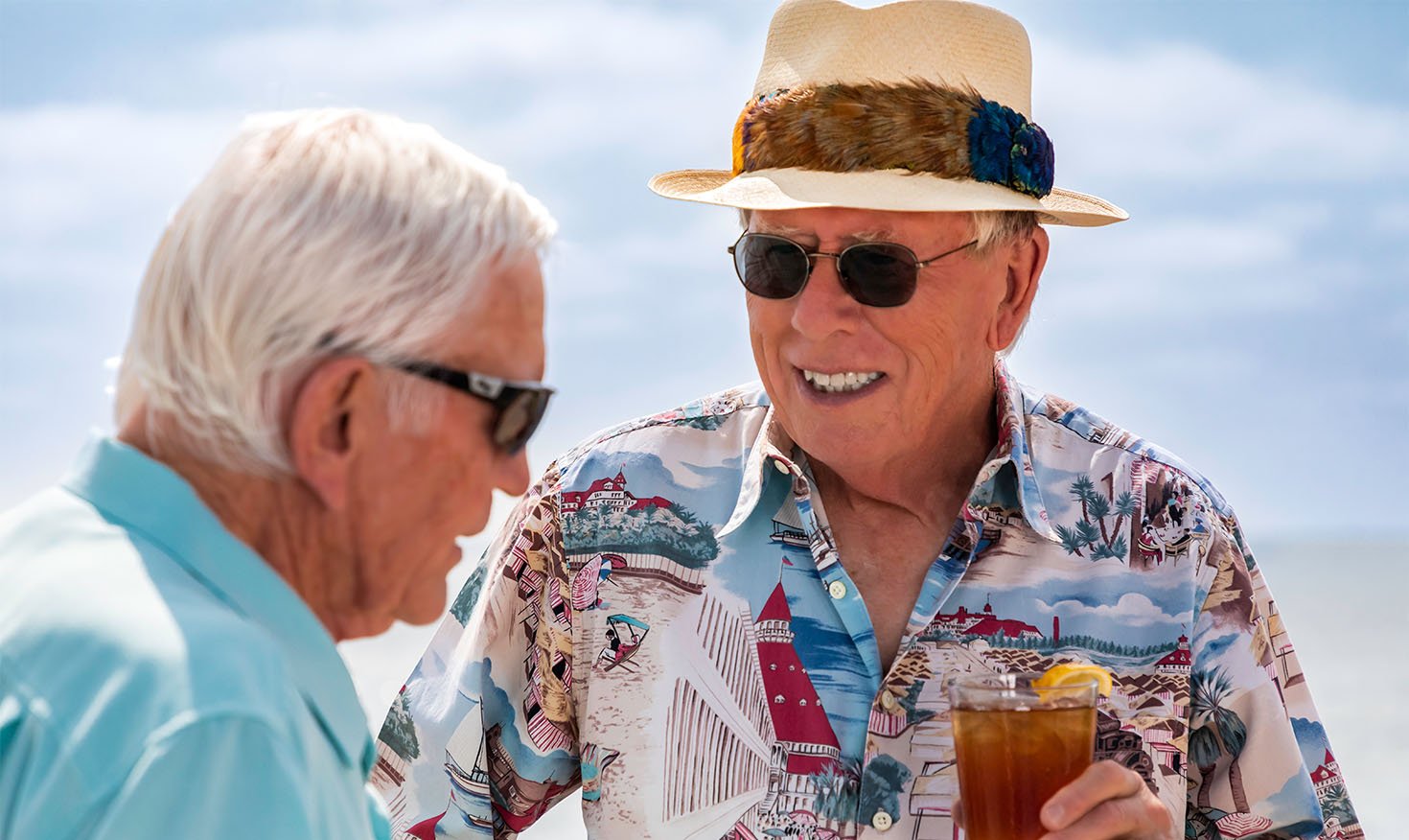 Two senior men enjoying iced tea outside