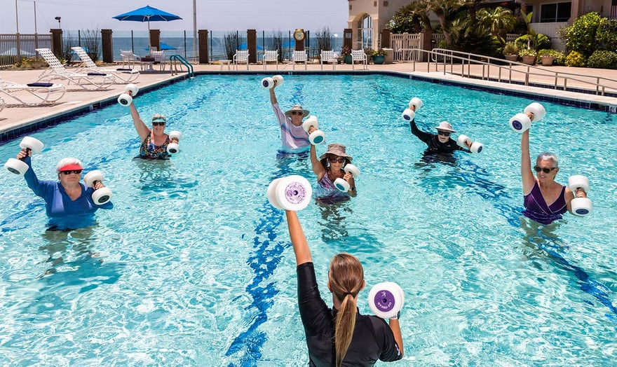 Group of seniors using water weights during an exercise class in the pool