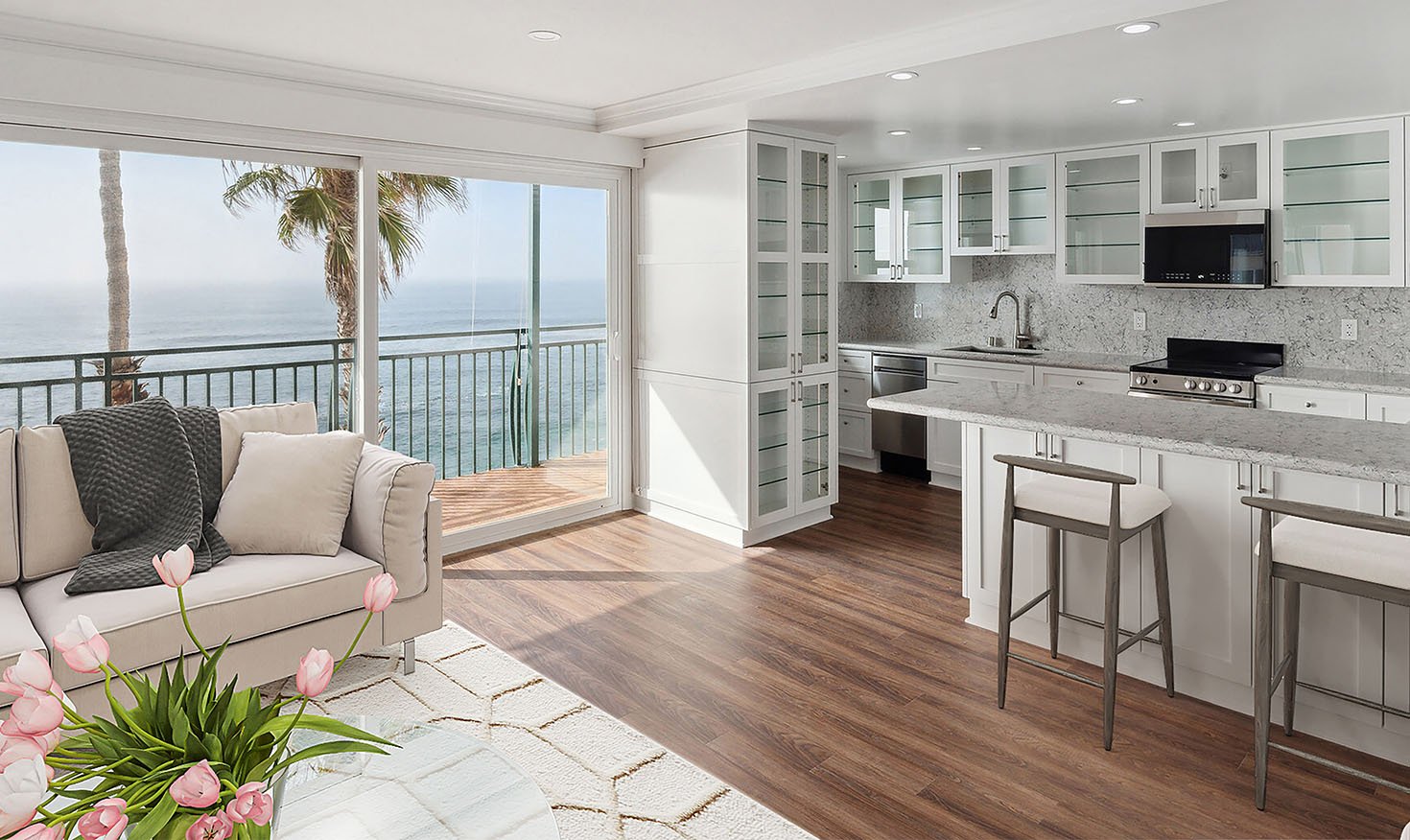 Living room and kitchen of an apartment with water views at White Sands La Jolla