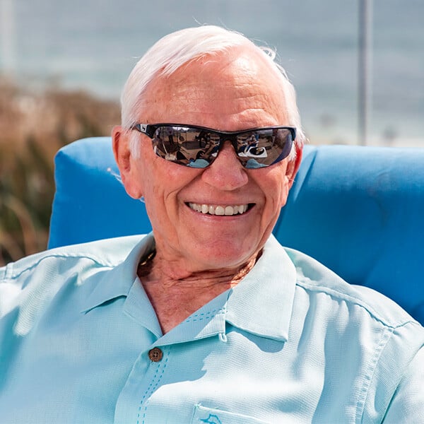 Smiling senior man wearing sunglasses while sitting outside