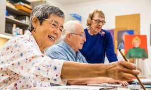 Three seniors in a community art class