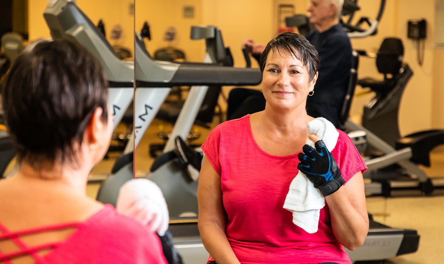 Woman holding a towel sitting in the White Sands fitness center