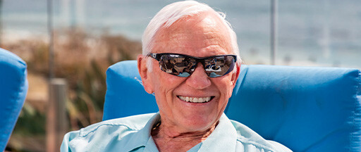 Smiling senior man wearing sunglasses while sitting outside