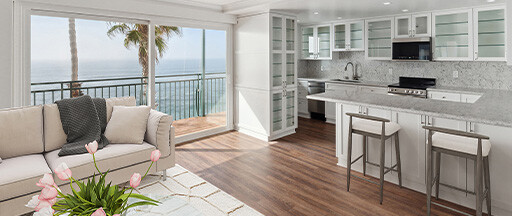 Living room and kitchen of an apartment with water views at White Sands La Jolla