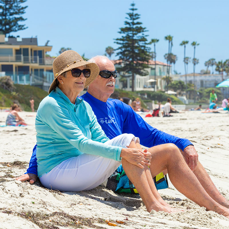 Senior couple sitting in the sand on the beach