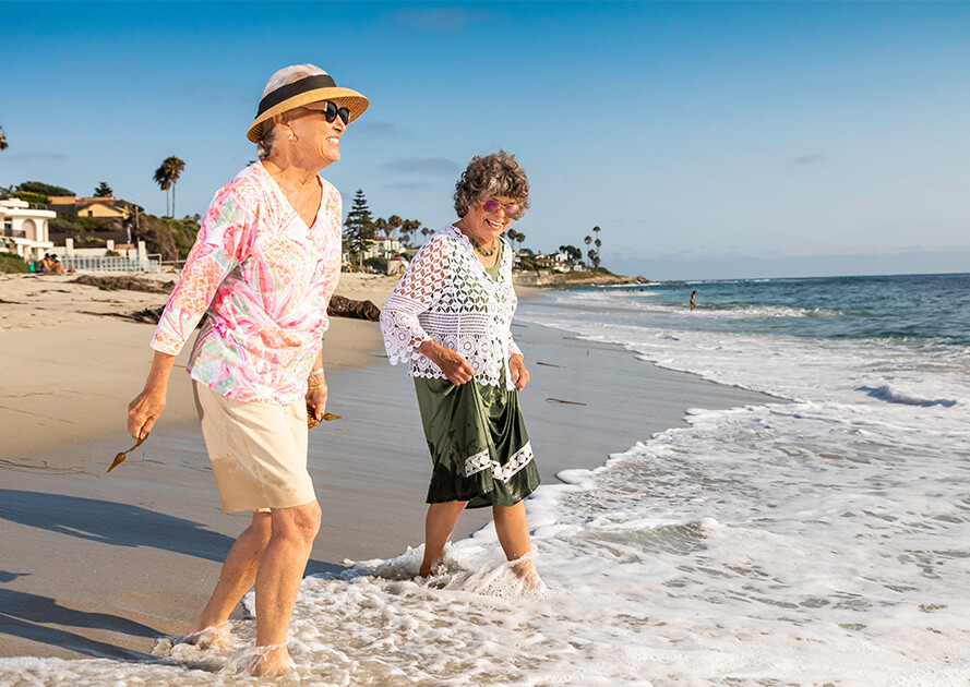 Two senior women in the water at the beach