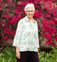 Ann smiling in front of flowers