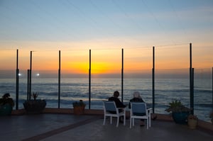 View of the sunset over the ocean from a walled patio