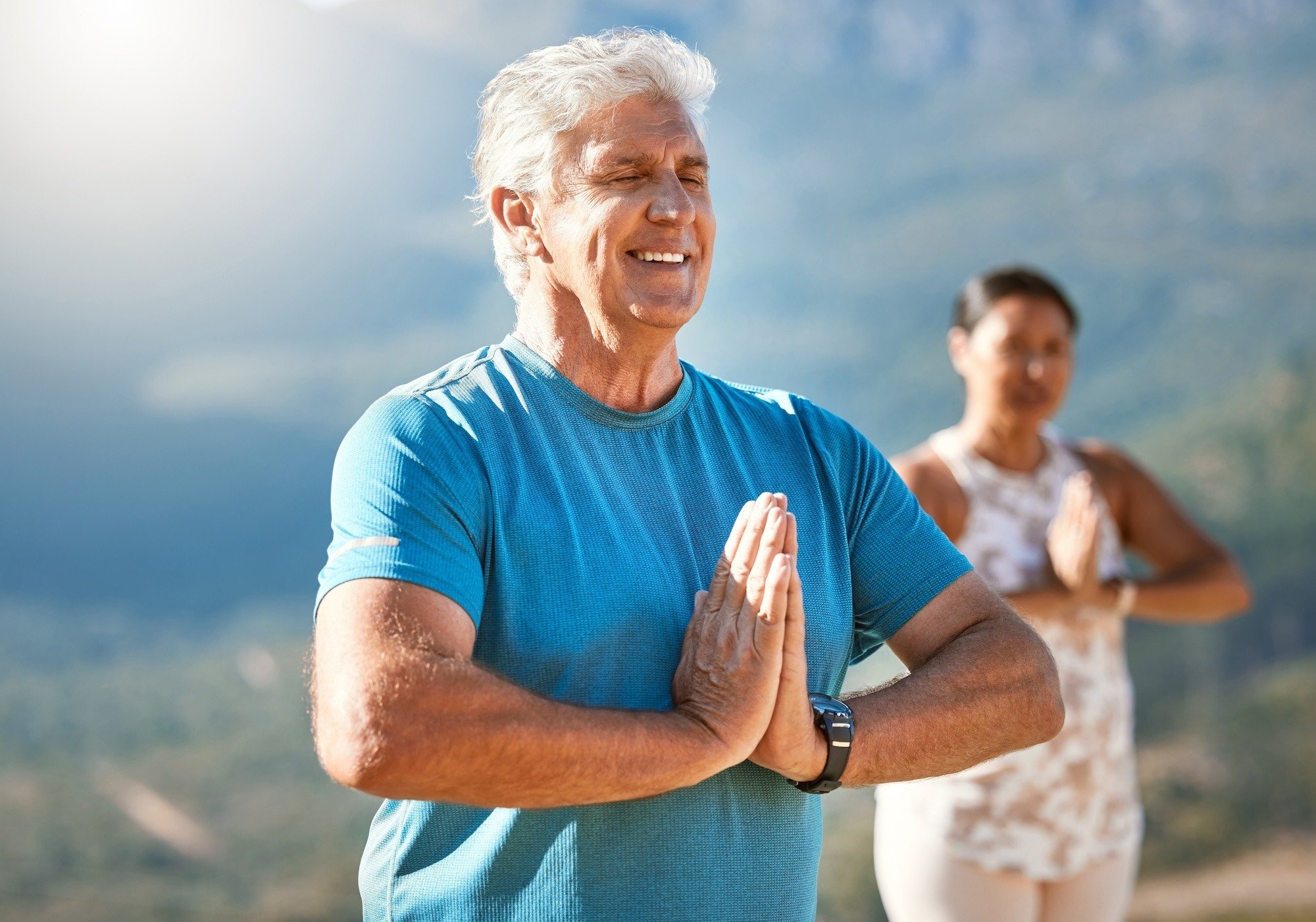 man practicing meditation outside with prayer hands and eyes closed