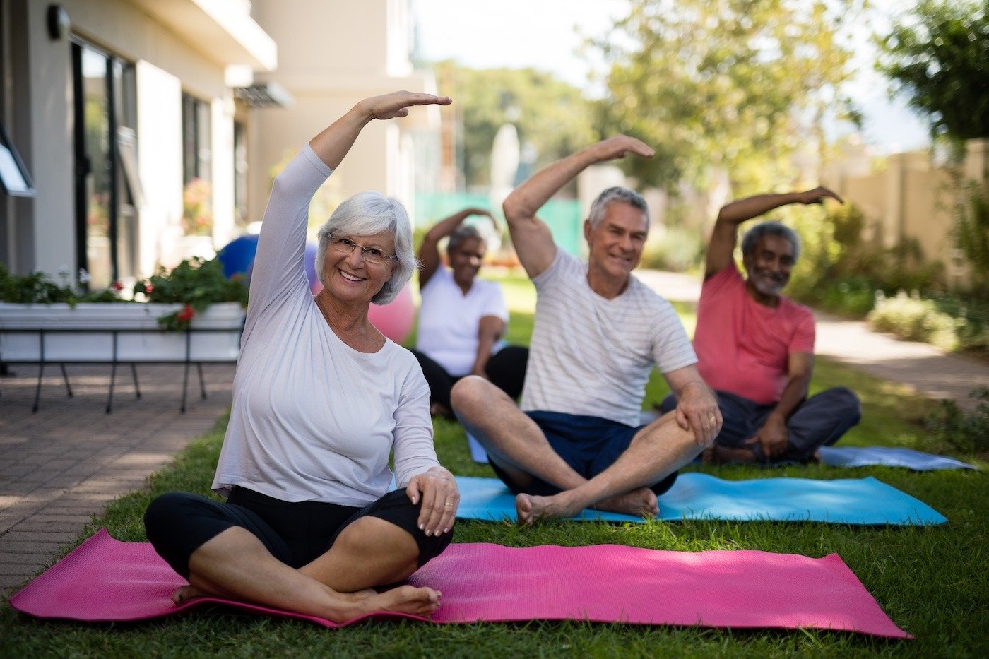 seniors working on their mobility and health at an outdoor yoga class