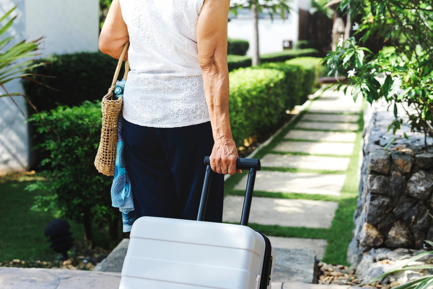 senior woman walking away from her lock and leave community to go on a trip