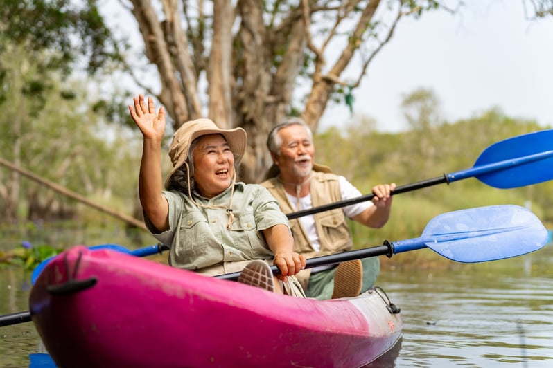 senior couple kayaking and smiling