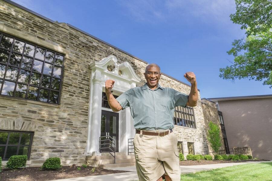 Happy man in front of main entrance