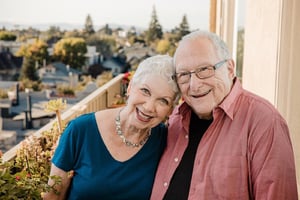 Smiling senior couple standing on the balcony of their apartment at Piedmont Gardens