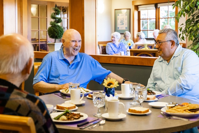 Three senior men eating lunch in The Terraces at Summitview dining room