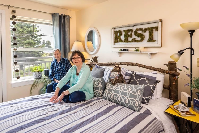 Seniors sitting in the bedroom of their apartment at The Terraces at Summitview
