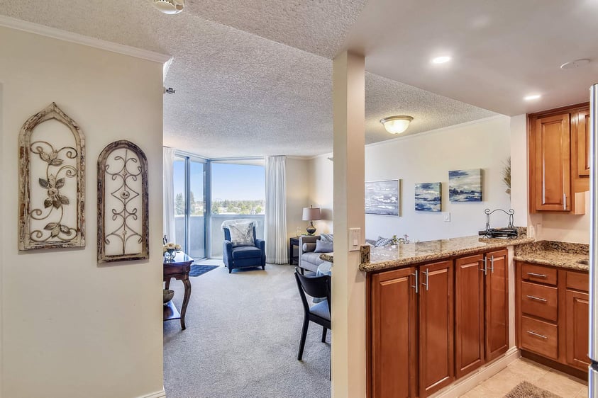 View of the living room and kitchen from the entryway of an apartment at Piedmont Gardens