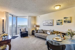 Living room and dining area in an apartment at Piedmont Gardens with sliding glass doors leading to a balcony